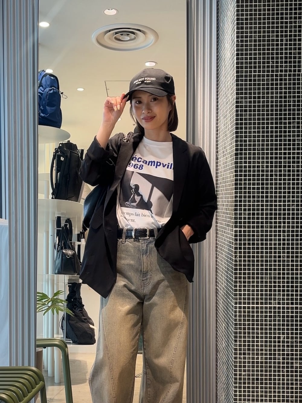 ブルー系のデニムパンツ、ブラック系のテーラードジャケット、ホワイト系のTシャツ/カットソーを着用したレディースの春コーディネートの3枚目の写真