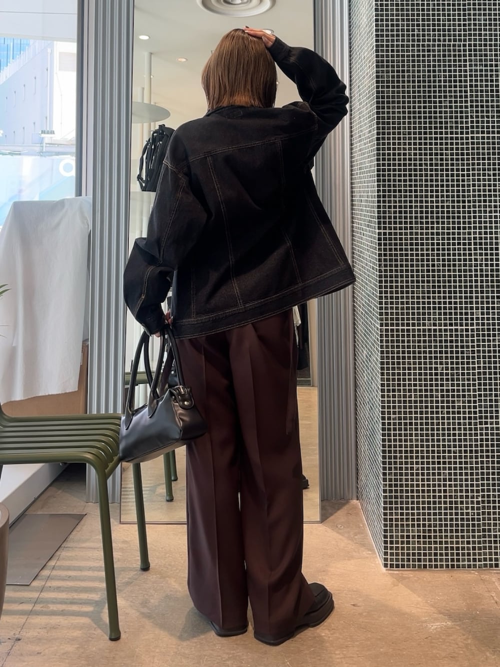 ブラウン系のスラックス、ブラック系のデニムジャケット、ホワイト系のTシャツ/カットソーを着用したレディースの春コーディネートの2枚目の写真