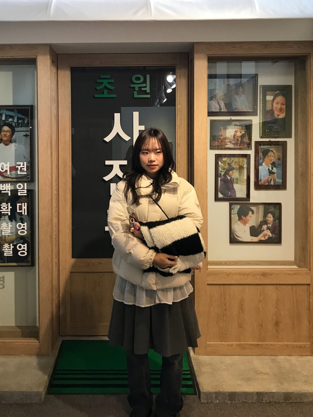 ホワイト系のダウンジャケット/コート、グレー系のデニムパンツ、グレー系のスカートを着用したレディースの春コーディネートの2枚目の写真