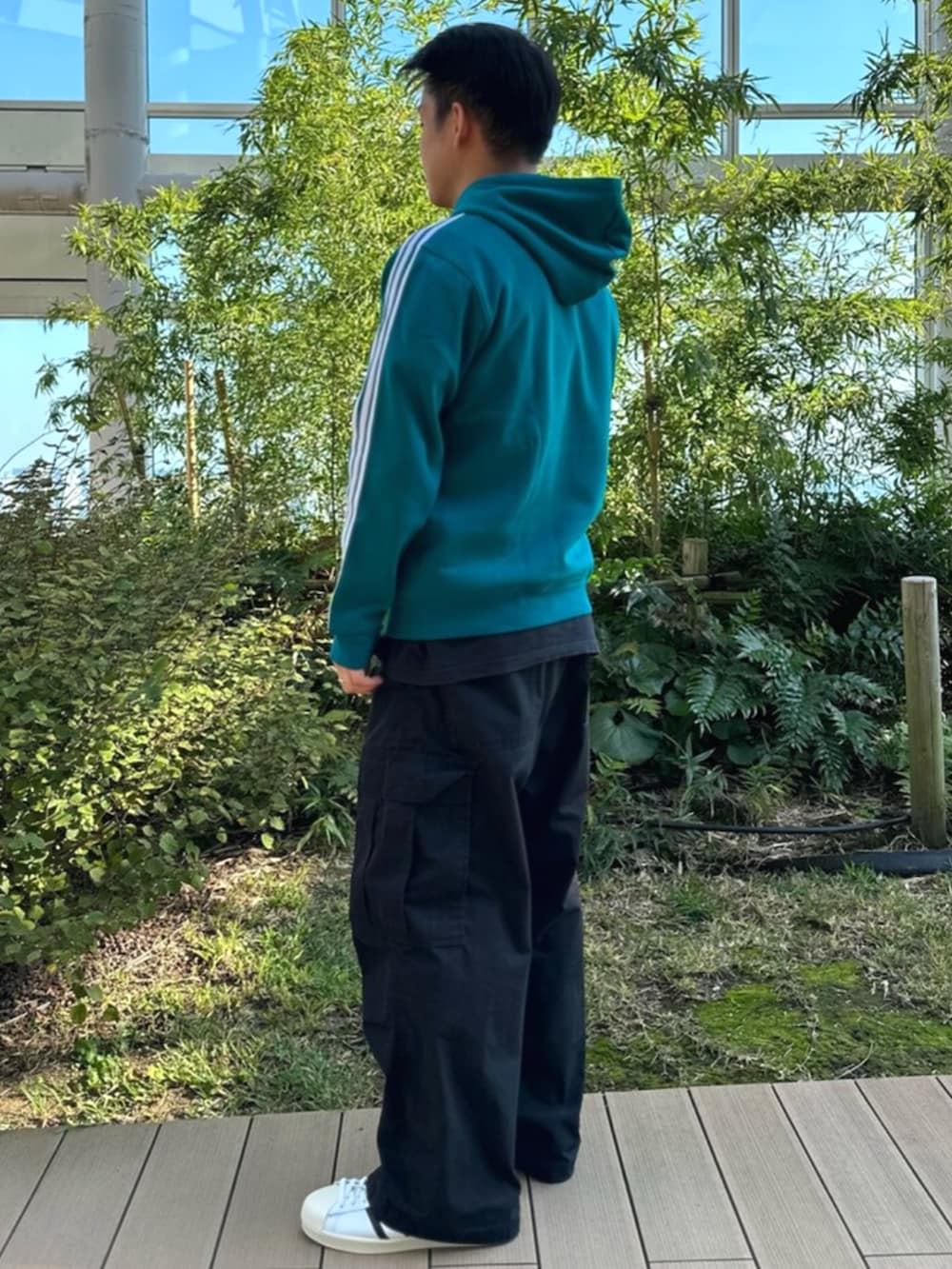 ブルー系のトップス、ブラック系のパーカーを着用したメンズの秋コーディネートの2枚目の写真