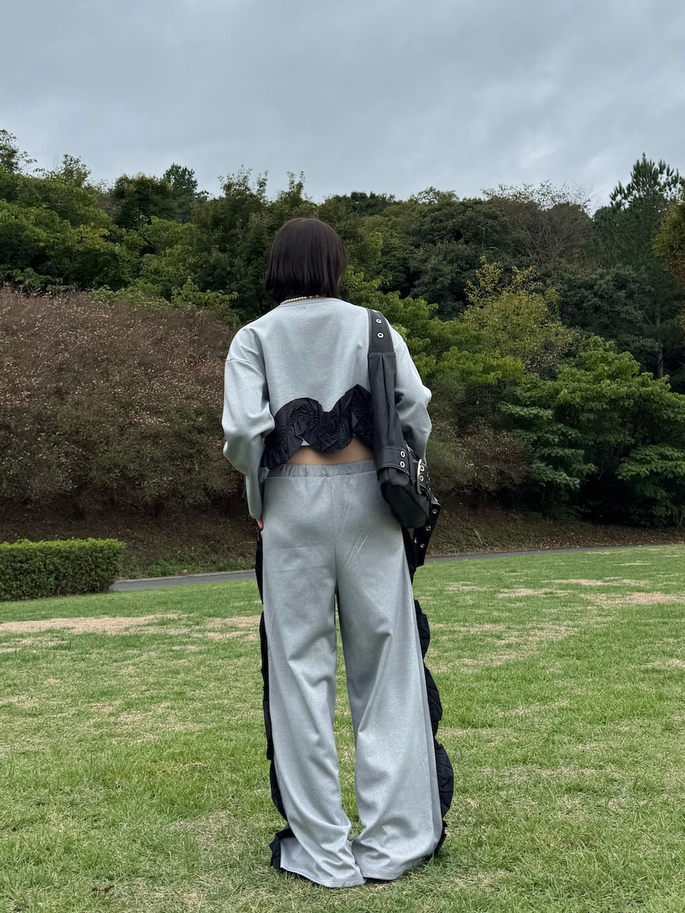 グレー系のスウェット、グレー系のスウェットパンツ、ブルー系のローファーを着用したレディースの秋コーディネートの2枚目の写真