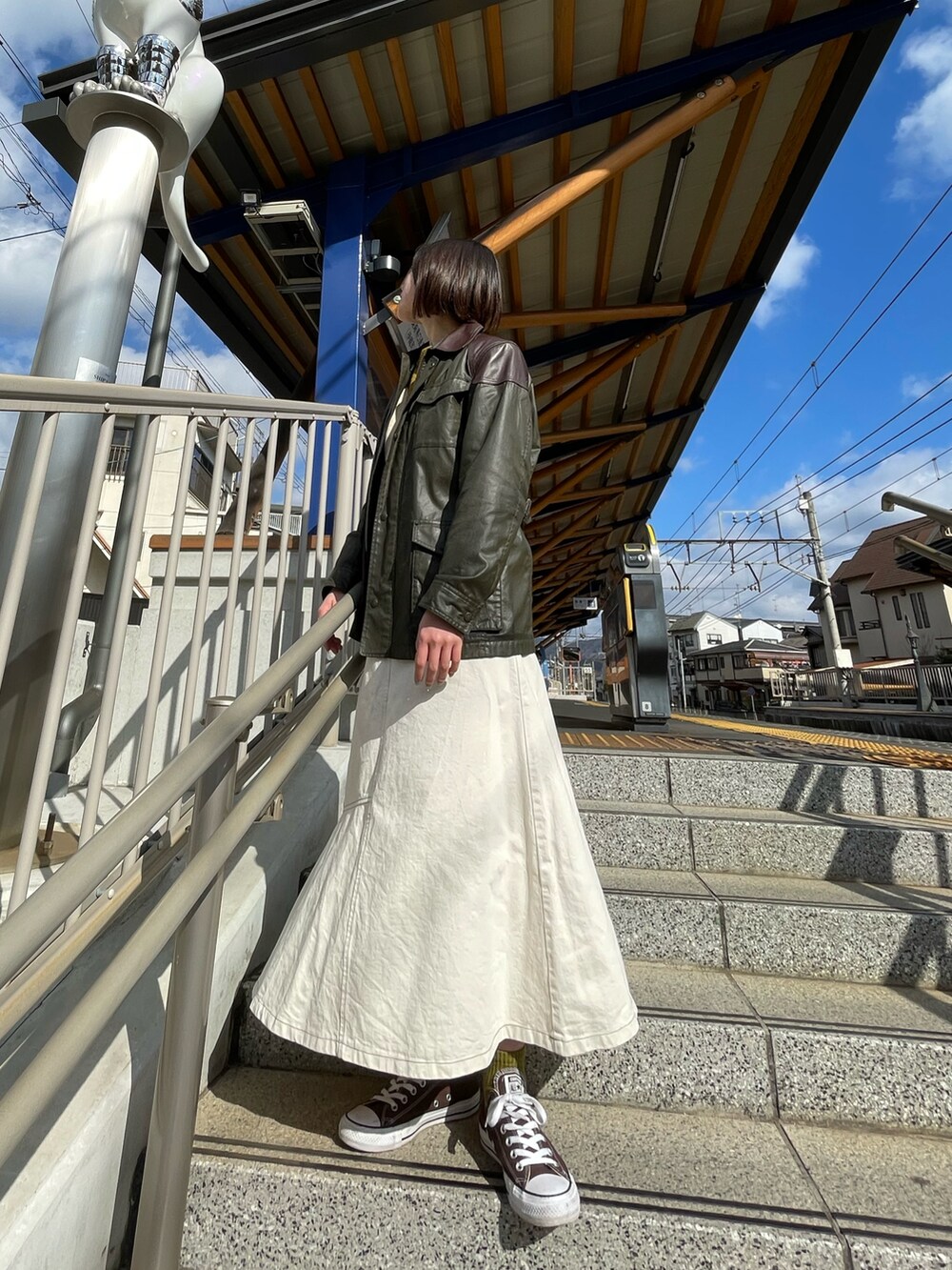 ブラウン系のスニーカー、ホワイト系のスカートを着用したレディースの秋コーディネートの3枚目の写真