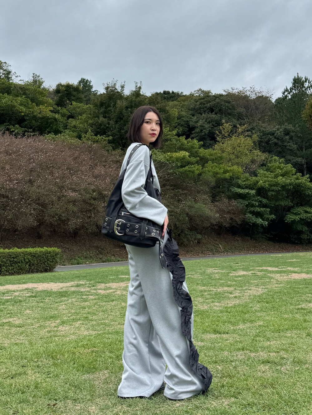 グレー系のスウェット、グレー系のスウェットパンツ、ブルー系のローファーを着用したレディースの秋コーディネートの3枚目の写真