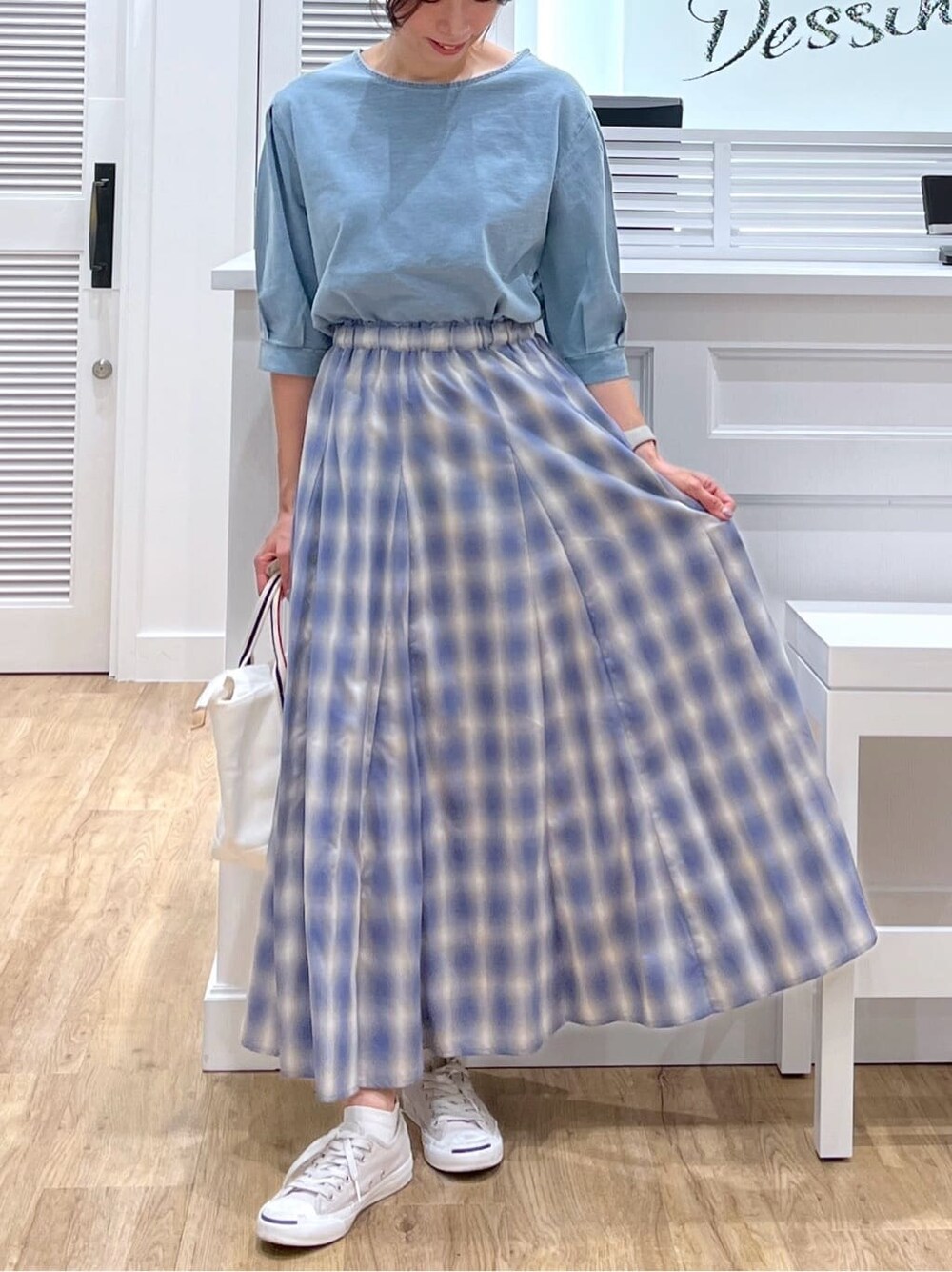 ブルー系のTシャツ/カットソー、ブラック系のスカート、ホワイト系のトートバッグを着用したレディースの夏コーディネートの5枚目の写真