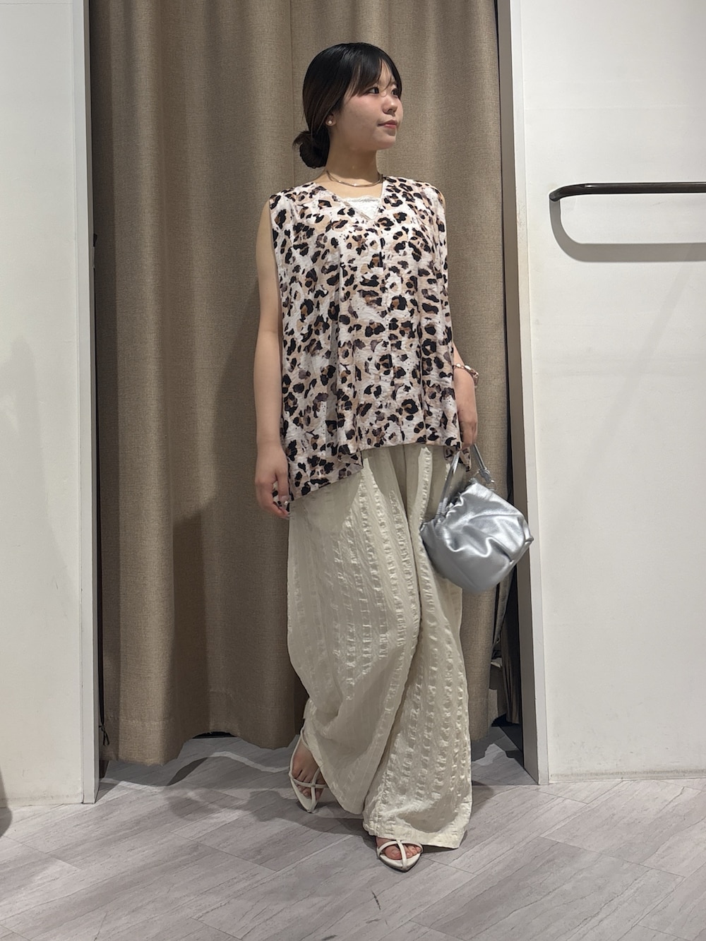 ホワイト系のその他パンツ、ホワイト系のシャツ/ブラウス、シルバー系のトートバッグを着用したレディースの夏コーディネートの2枚目の写真