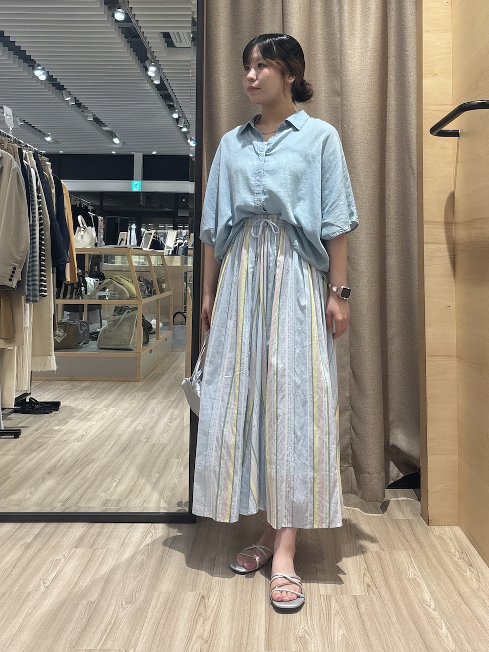 ブルー系のシャツ/ブラウス、ブルー系のスカート、ブラック系のトートバッグを着用したレディースの夏コーディネートの3枚目の写真