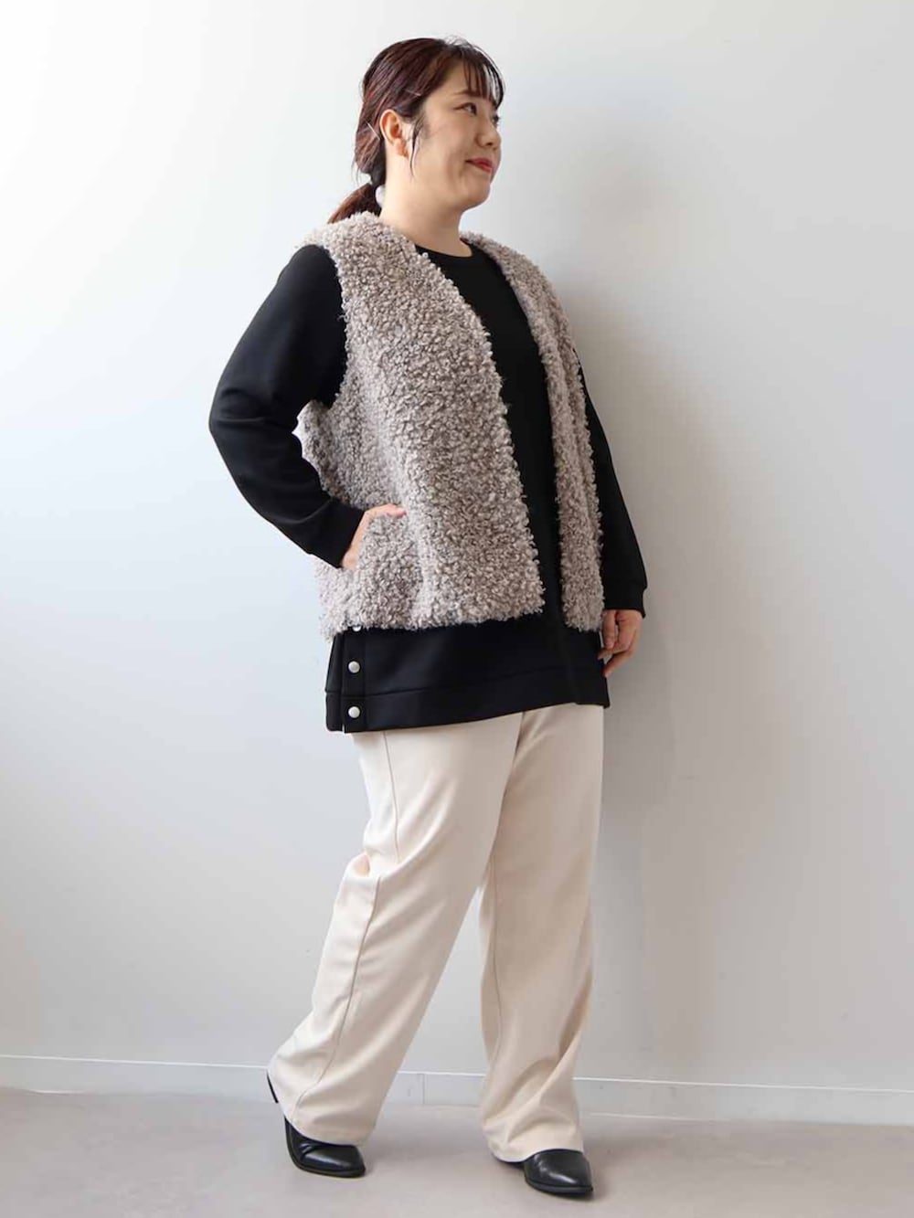 グレー系のその他アウター、ブラック系のチュニック、ベージュ系のその他パンツを着用したレディースの冬コーディネートの2枚目の写真