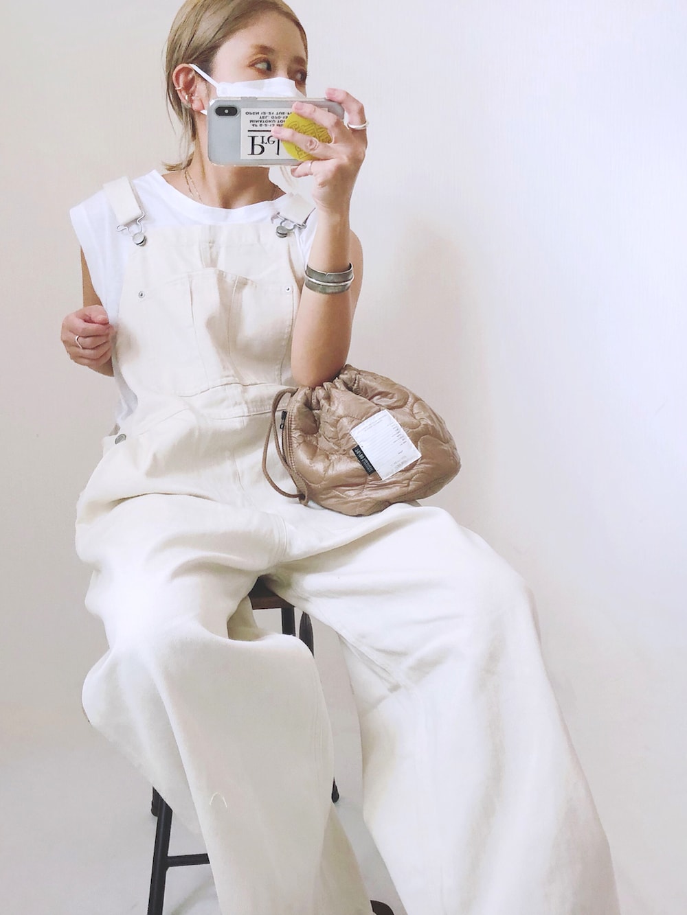 ホワイト系のサロペット/オーバーオール、ベージュ系のハンドバッグを着用したレディースの夏コーディネートの2枚目の写真