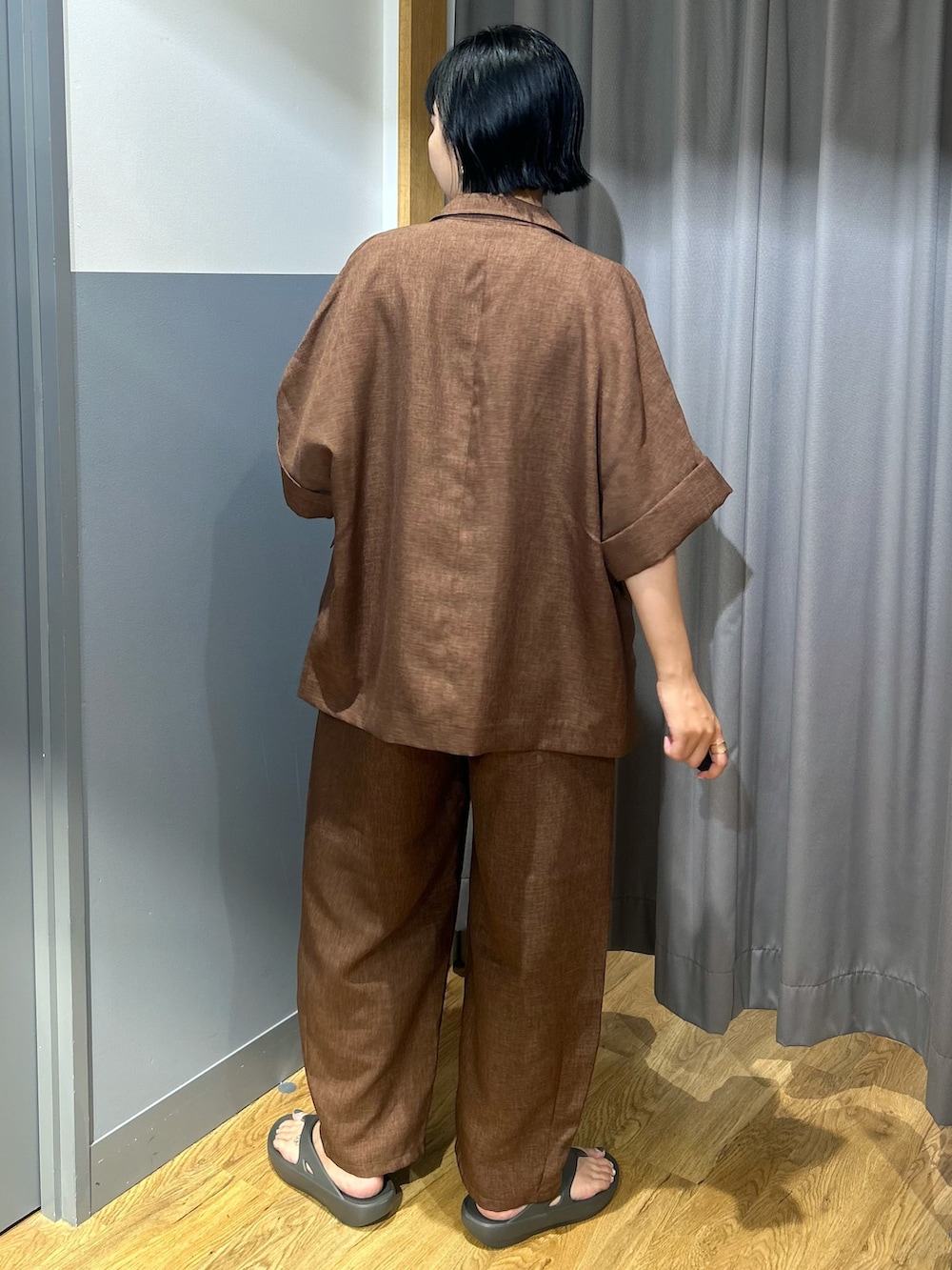ブラウン系のテーラードジャケット、ブラウン系のその他パンツ、ホワイト系のタンクトップを着用したレディースの夏コーディネートの3枚目の写真