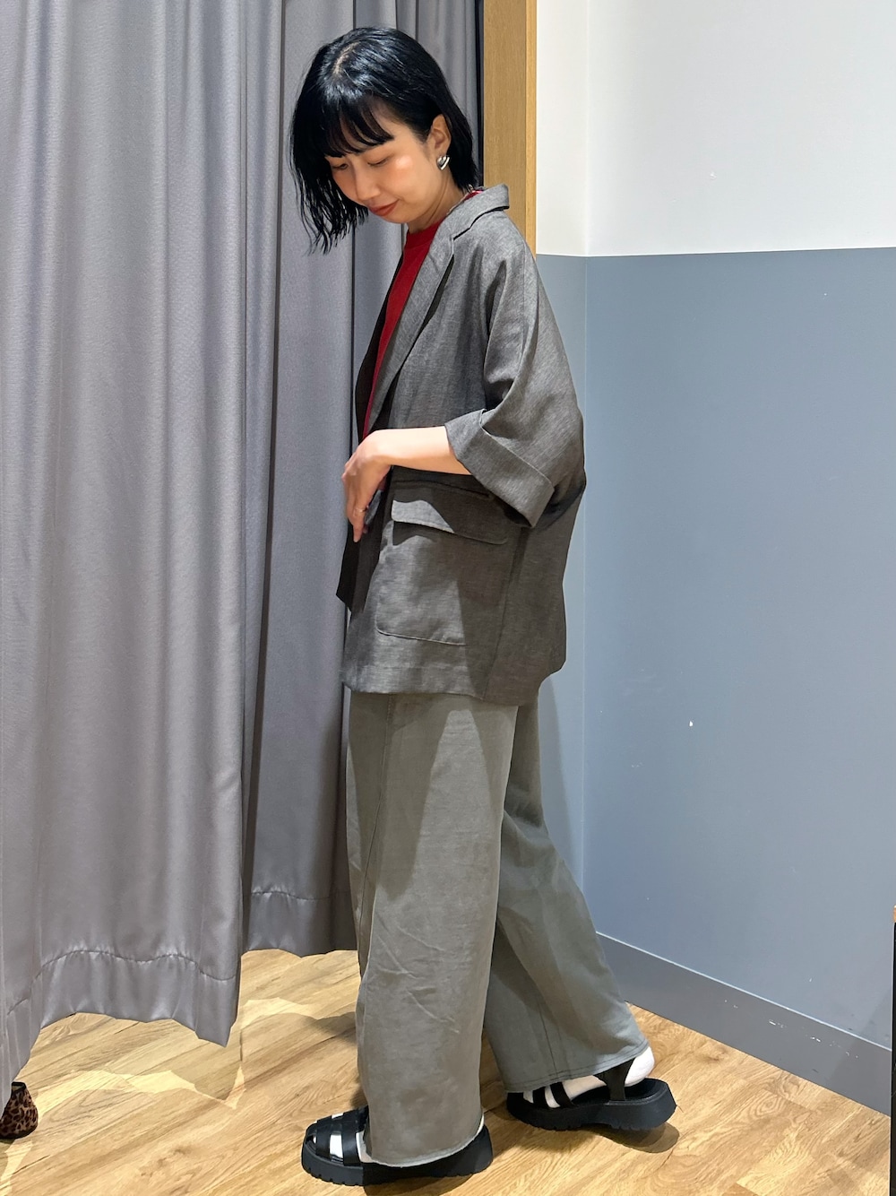 グレー系のテーラードジャケット、レッド系のTシャツ/カットソー、グレー系のその他パンツを着用したレディースの夏コーディネートの2枚目の写真