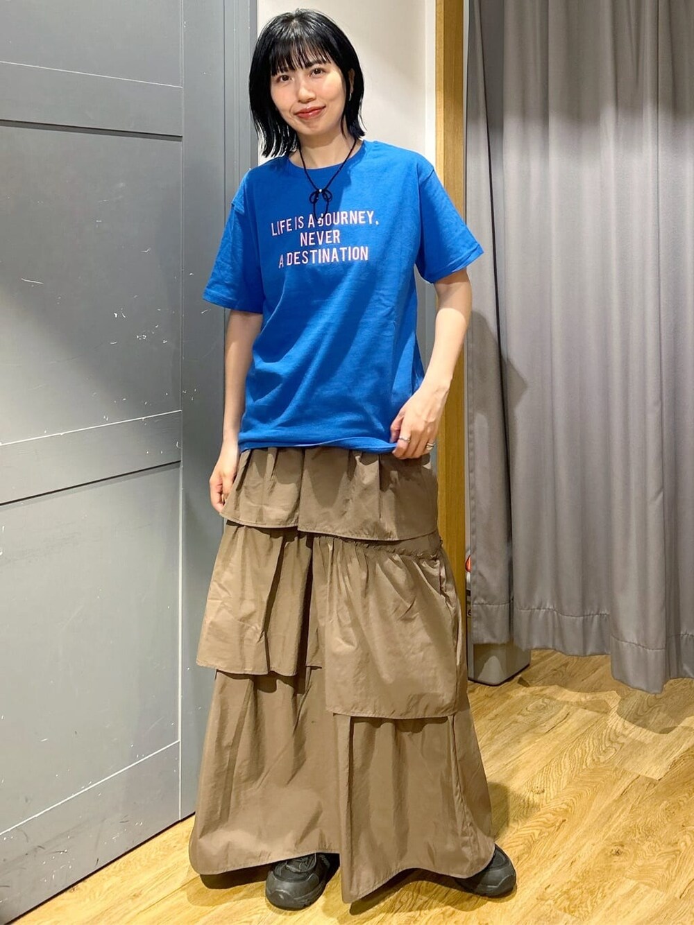 ブルー系のTシャツ/カットソー、ブラウン系のスカート、ベージュ系のシャツ/ブラウスを着用したレディースの春コーディネートの5枚目の写真