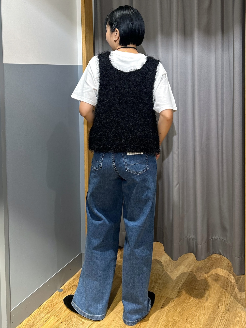 ホワイト系のTシャツ/カットソー、ブラック系のベスト、ブルー系のデニムパンツを着用したレディースの夏コーディネートの3枚目の写真