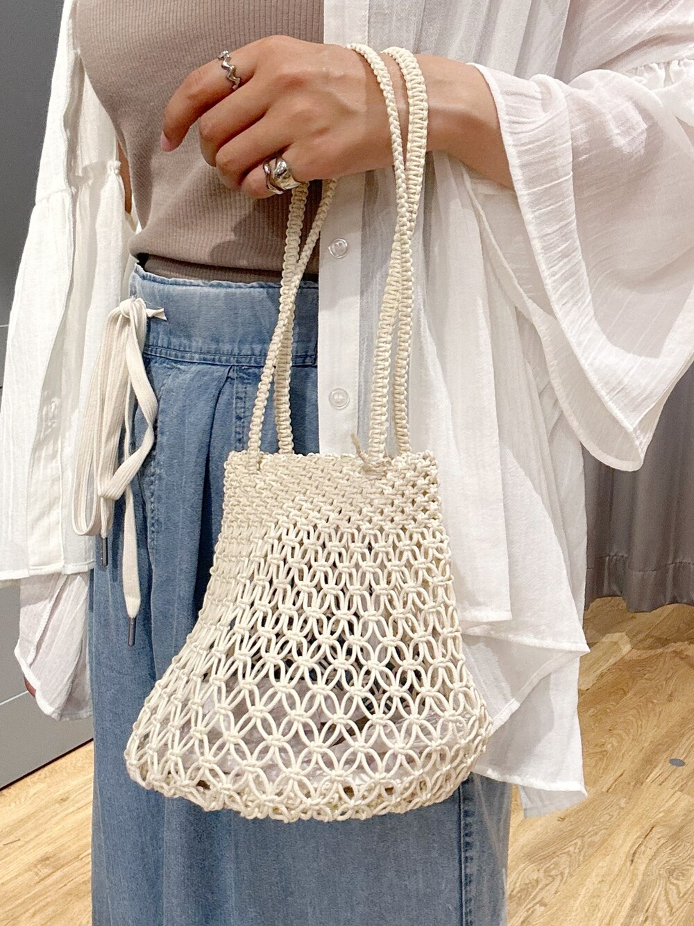 ベージュ系のタンクトップ、ホワイト系のシャツ/ブラウス、ブルー系のデニムパンツを着用したレディースの夏コーディネートの8枚目の写真