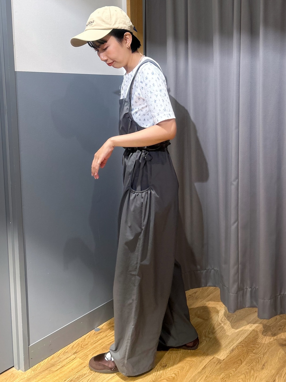 グリーン系のサロペット/オーバーオール、ブルー系のTシャツ/カットソー、ベージュ系のキャップを着用したレディースの夏コーディネートの2枚目の写真