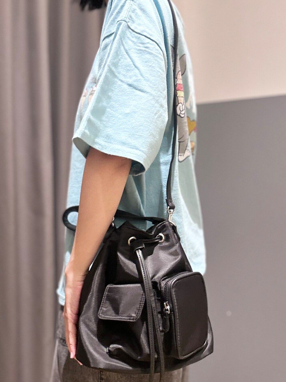 ブルー系のTシャツ/カットソー、ブラック系のデニムパンツ、ブラック系のショルダーバッグを着用したレディースの夏コーディネートの8枚目の写真