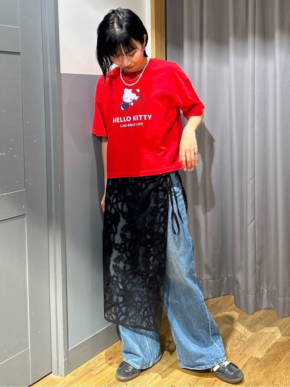 レッド系のTシャツ/カットソー、ブラック系のスカート、ブラック系のショルダーバッグを着用したレディースの春コーディネートの2枚目の写真