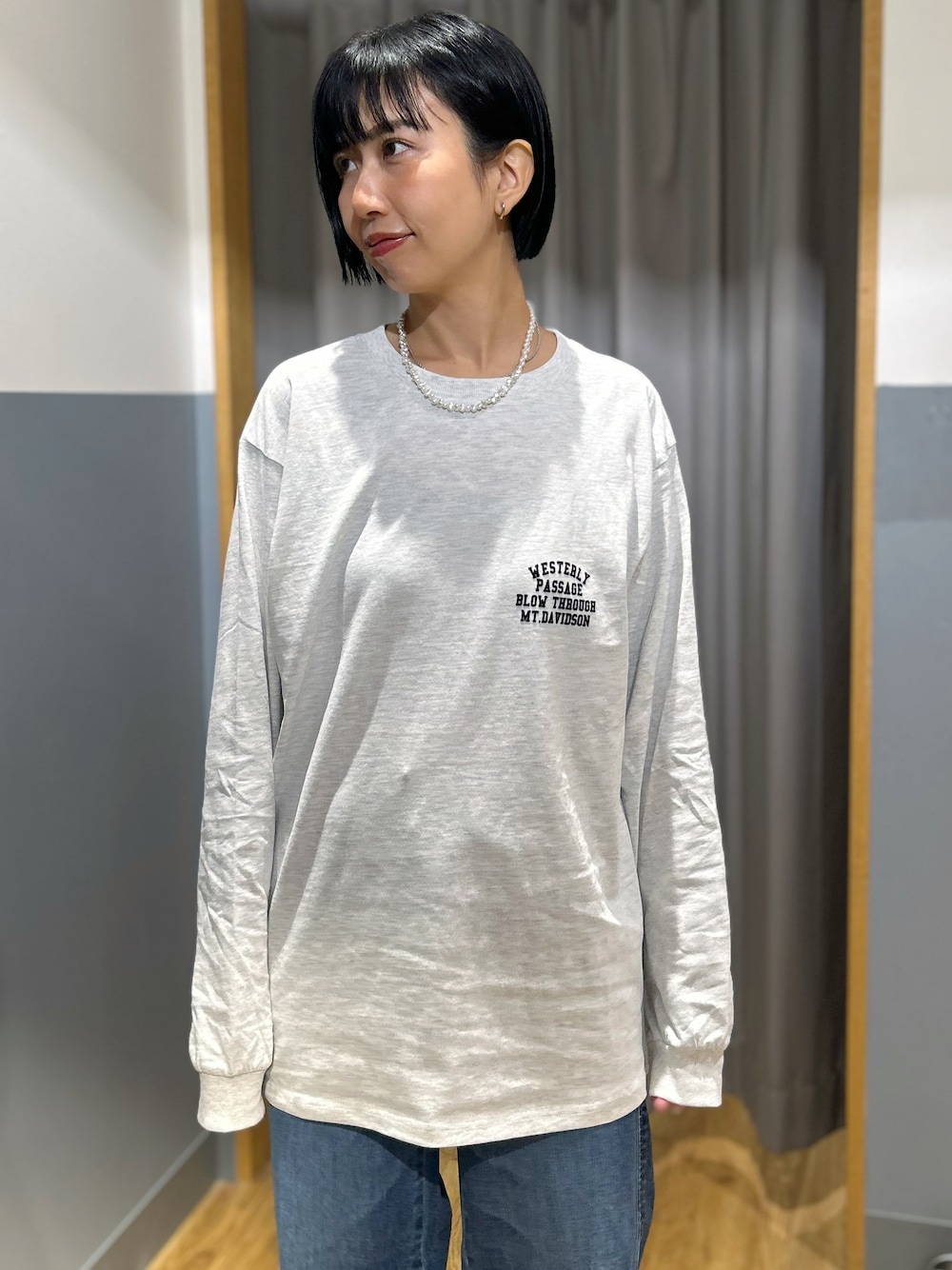グレー系のテーラードジャケット、グレー系のTシャツ/カットソー、ブルー系のデニムパンツを着用したレディースの秋コーディネートの4枚目の写真