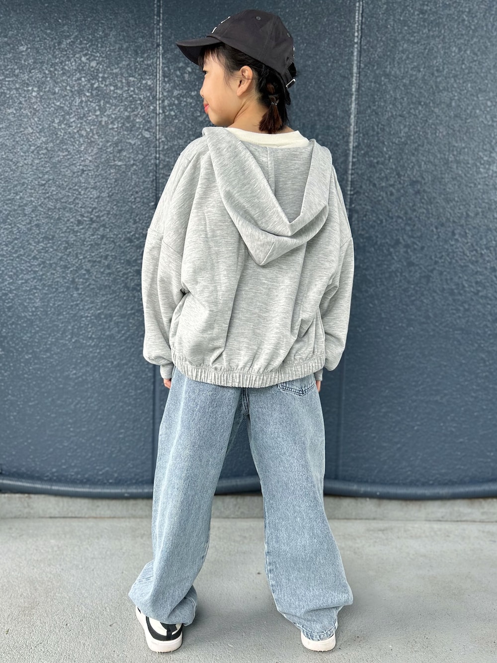 グレー系のカーディガン/ボレロ、ホワイト系のニット/セーター、ブルー系のその他パンツを着用したキッズの秋コーディネートの3枚目の写真