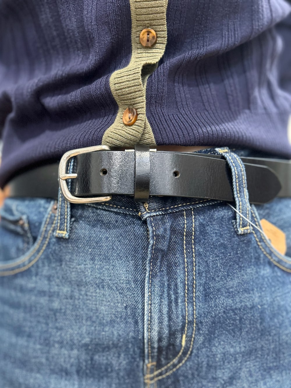 ブルー系のニット/セーター、ブルー系のデニムパンツ、グリーン系のショルダーバッグを着用したレディースの秋コーディネートの7枚目の写真
