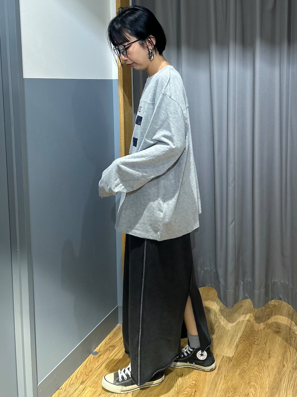 グレー系のTシャツ/カットソー、グレー系のスカート、ブラック系のボディバッグ/ウエストポーチを着用したレディースの秋コーディネートの2枚目の写真