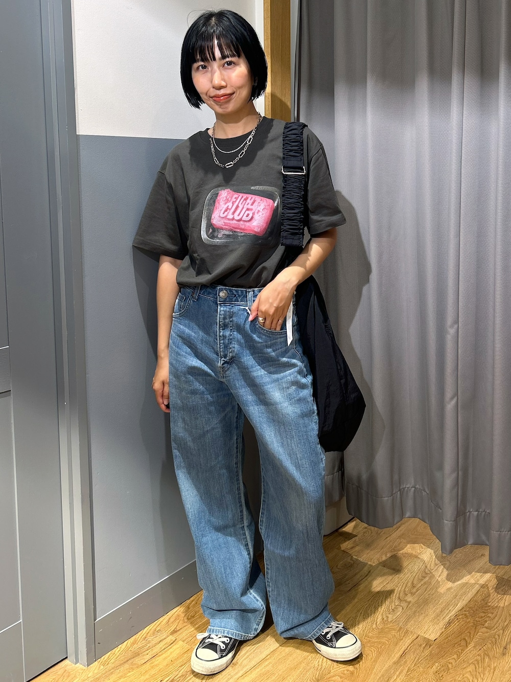 グレー系のTシャツ/カットソー、ブルー系のデニムパンツ、ブラック系のショルダーバッグを着用したレディースの夏コーディネートの2枚目の写真