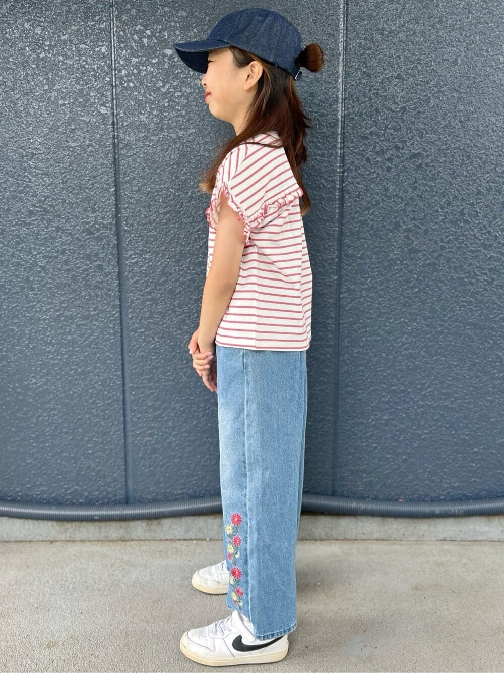 レッド系のTシャツ/カットソー、ブルー系のデニムパンツ、ブルー系のキャップを着用したキッズの春コーディネートの2枚目の写真
