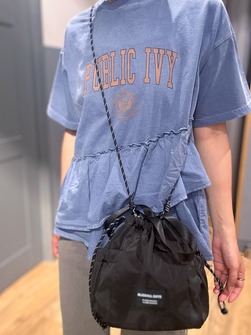 ブルー系のTシャツ/カットソー、グレー系のその他パンツ、ブラック系のショルダーバッグを着用したレディースの春コーディネートの7枚目の写真