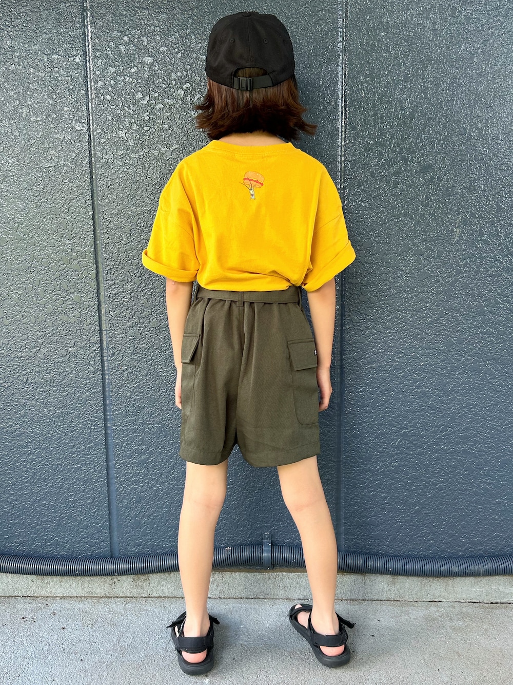 イエロー系のニット/セーター、ブラウン系のその他パンツ、ブラック系のキャップを着用したキッズの夏コーディネートの3枚目の写真