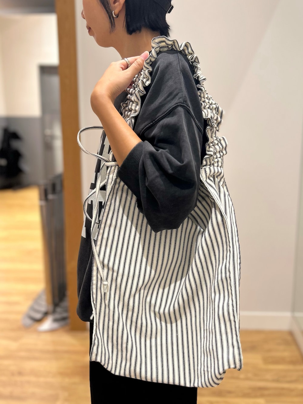 グレー系のスウェット、ブラック系のその他パンツ、ブラック系のトートバッグを着用したレディースの秋コーディネートの7枚目の写真