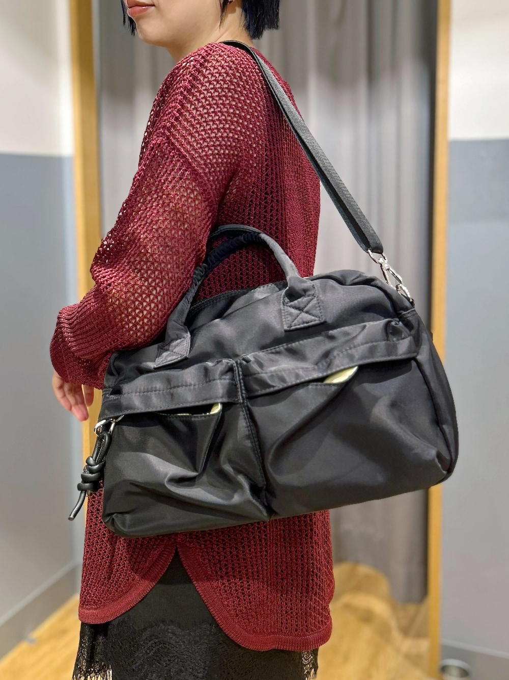 レッド系のニット/セーター、ブラック系のタンクトップ、ブルー系のデニムパンツを着用したレディースの秋コーディネートの10枚目の写真