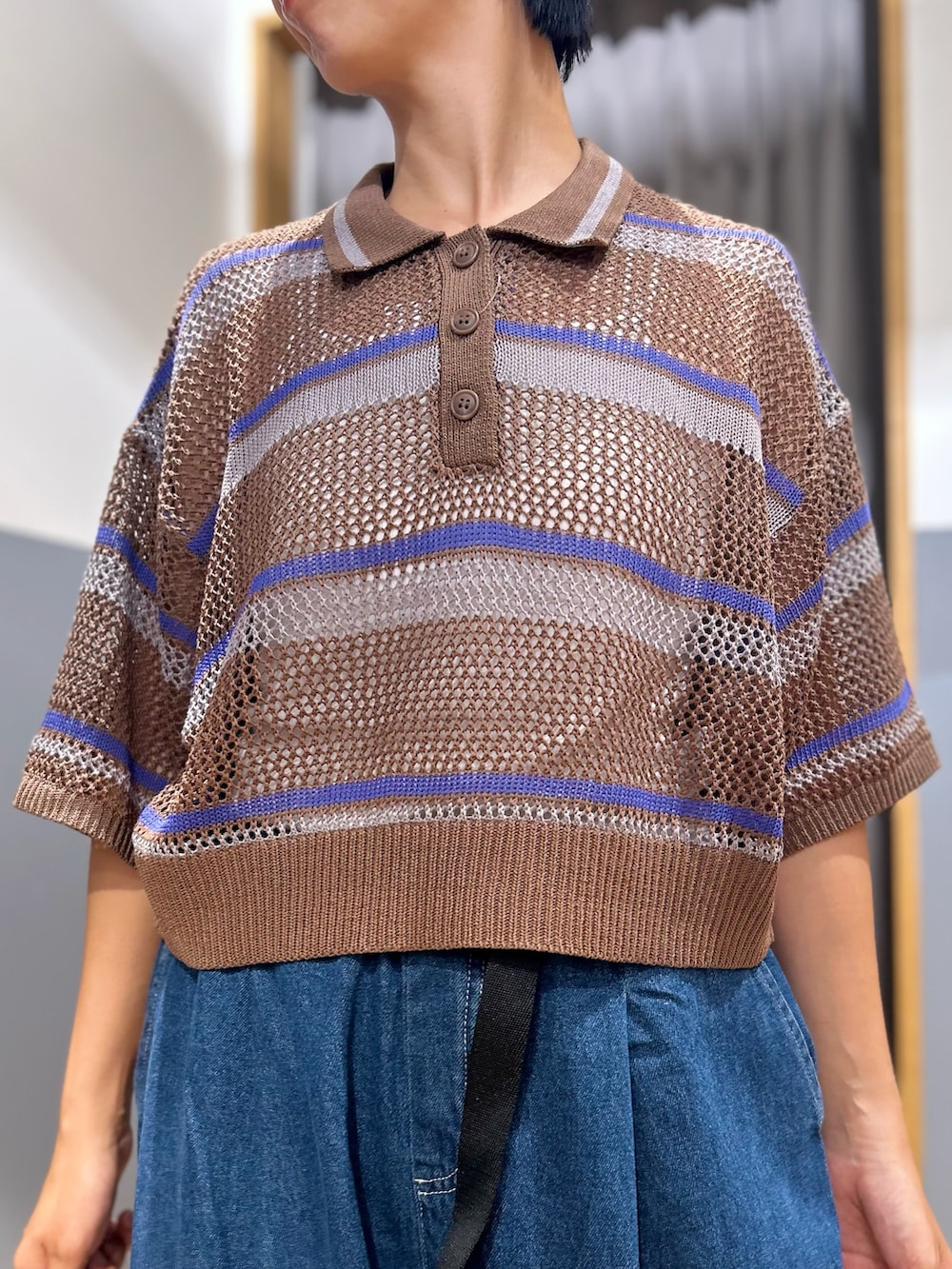 グレー系のニット/セーター、ブルー系のその他パンツ、ベージュ系のショルダーバッグを着用したレディースの夏コーディネートの4枚目の写真