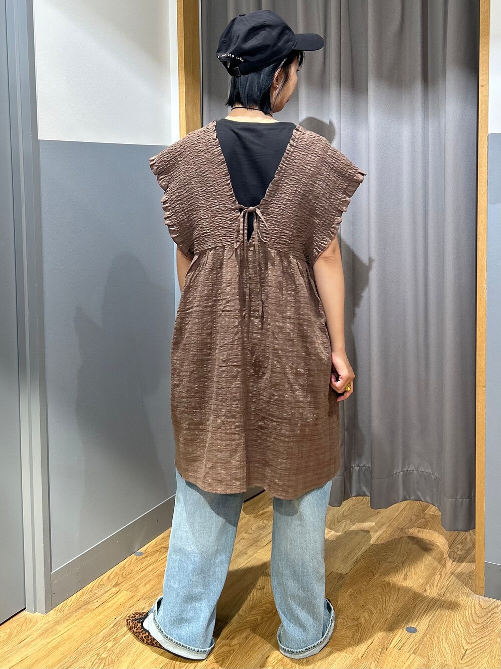 ブルー系のデニムパンツ、ブラック系のキャップを着用したレディースの夏コーディネートの3枚目の写真