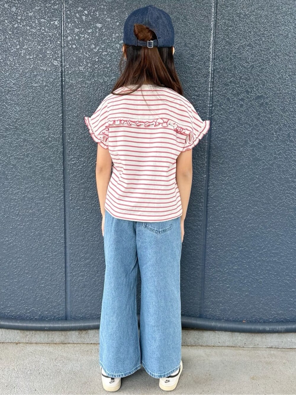 レッド系のTシャツ/カットソー、ブルー系のデニムパンツ、ブルー系のキャップを着用したキッズの春コーディネートの3枚目の写真