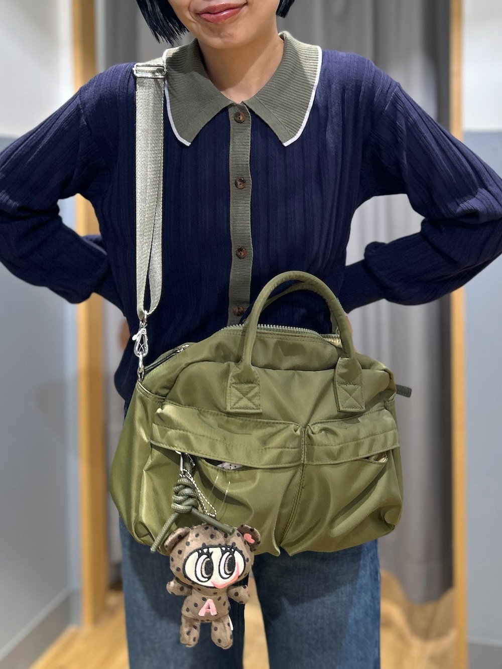 ブルー系のニット/セーター、ブルー系のデニムパンツ、グリーン系のショルダーバッグを着用したレディースの秋コーディネートの9枚目の写真