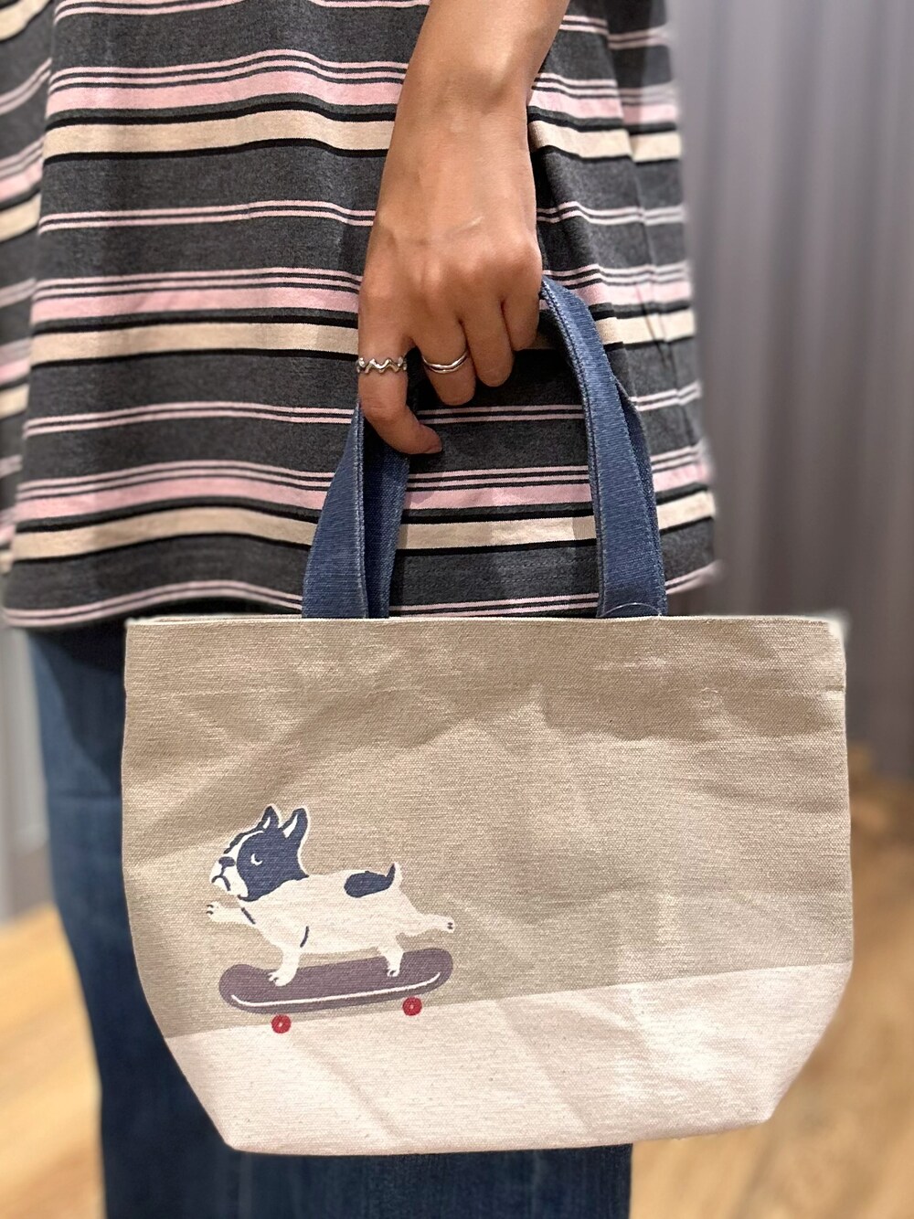 グレー系のTシャツ/カットソー、ブルー系のデニムパンツ、ベージュ系のトートバッグを着用したレディースの夏コーディネートの9枚目の写真