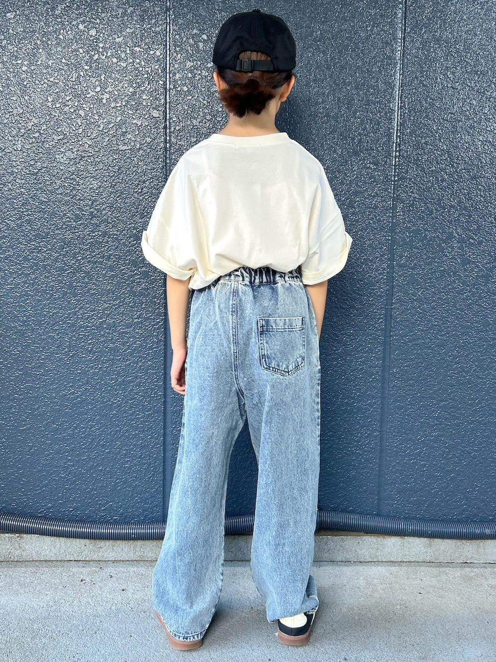 ホワイト系のTシャツ/カットソー、ブルー系のデニムパンツ、ブラック系のキャップを着用したキッズの夏コーディネートの3枚目の写真