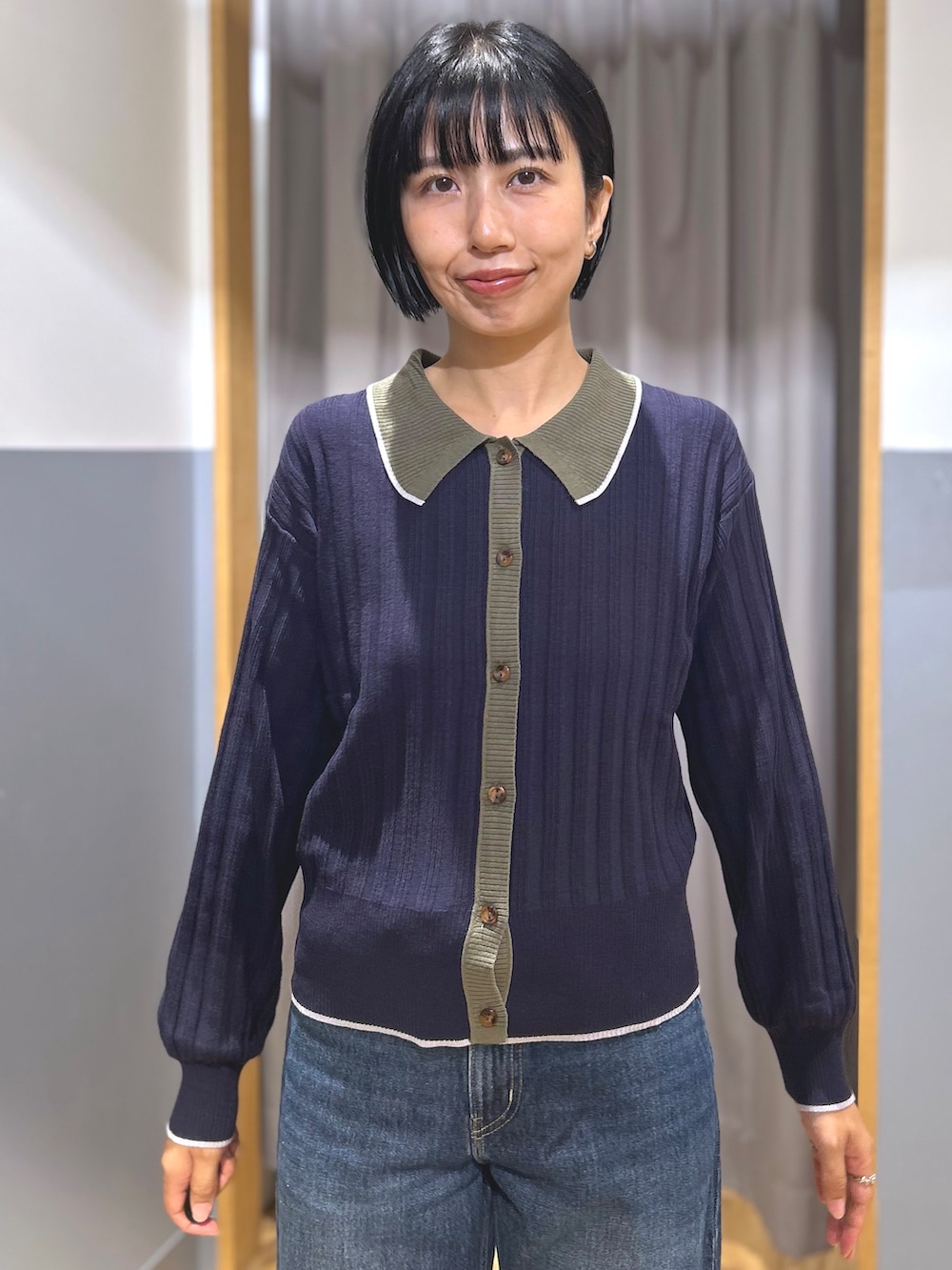 ブルー系のニット/セーター、ブルー系のデニムパンツ、グリーン系のショルダーバッグを着用したレディースの秋コーディネートの4枚目の写真