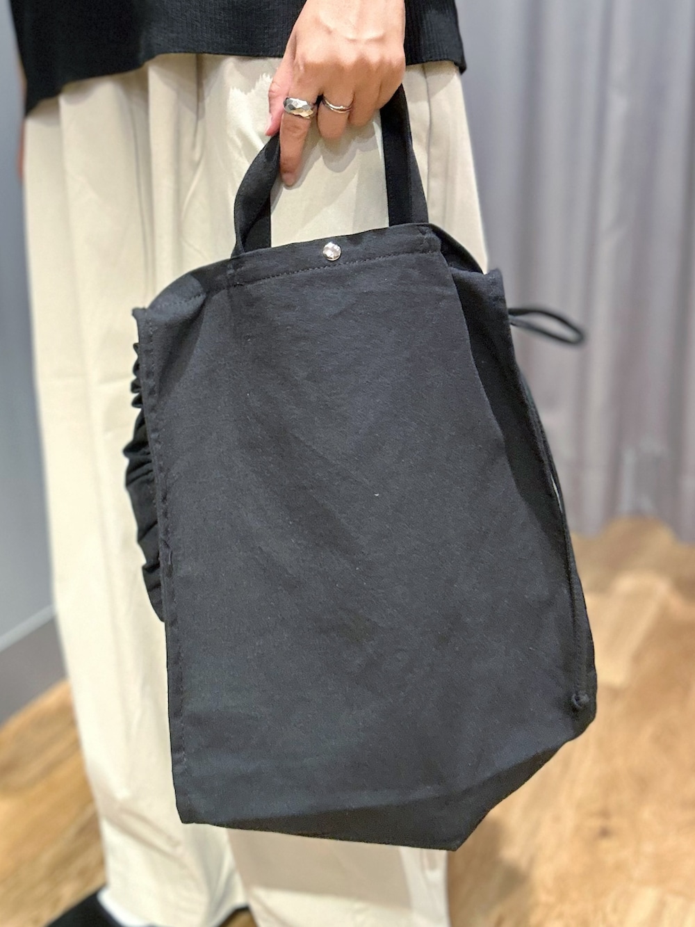 ブラック系のニット/セーター、グレー系のその他パンツ、ブラック系のトートバッグを着用したレディースの夏コーディネートの9枚目の写真