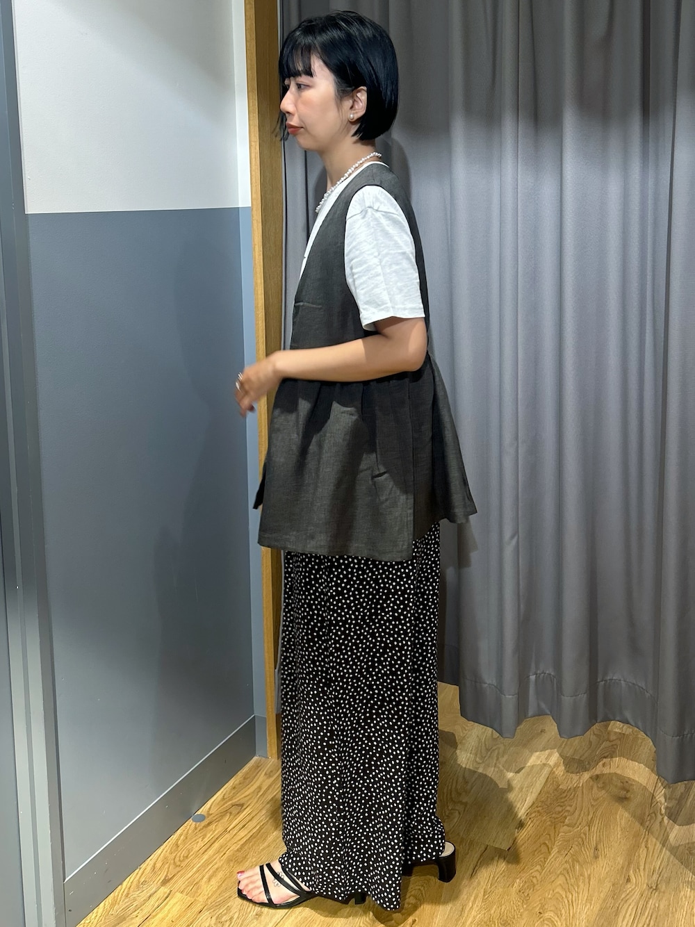 ホワイト系のその他パンツ、グレー系のベスト、ブラック系のショルダーバッグを着用したレディースの夏コーディネートの2枚目の写真
