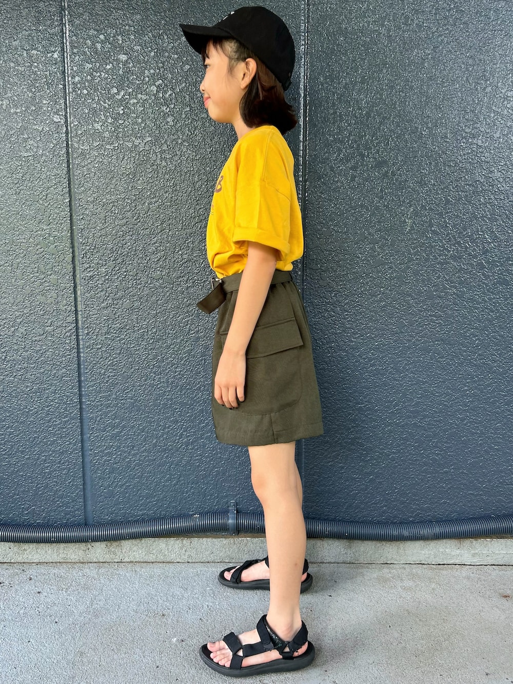 イエロー系のニット/セーター、ブラウン系のその他パンツ、ブラック系のキャップを着用したキッズの夏コーディネートの2枚目の写真