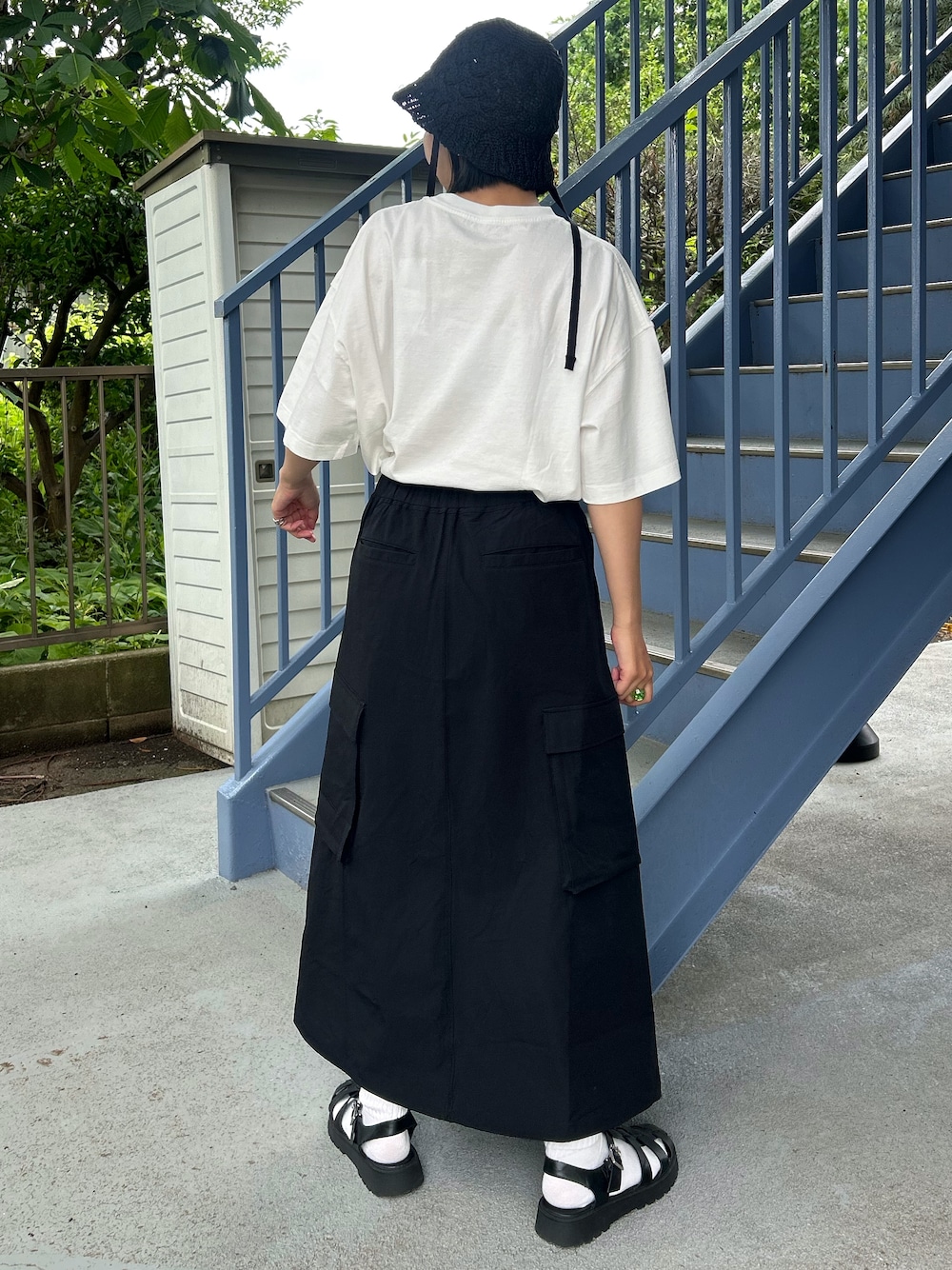 ホワイト系のTシャツ/カットソー、ブラック系のスカート、ブラック系のハットを着用したレディースの春コーディネートの4枚目の写真