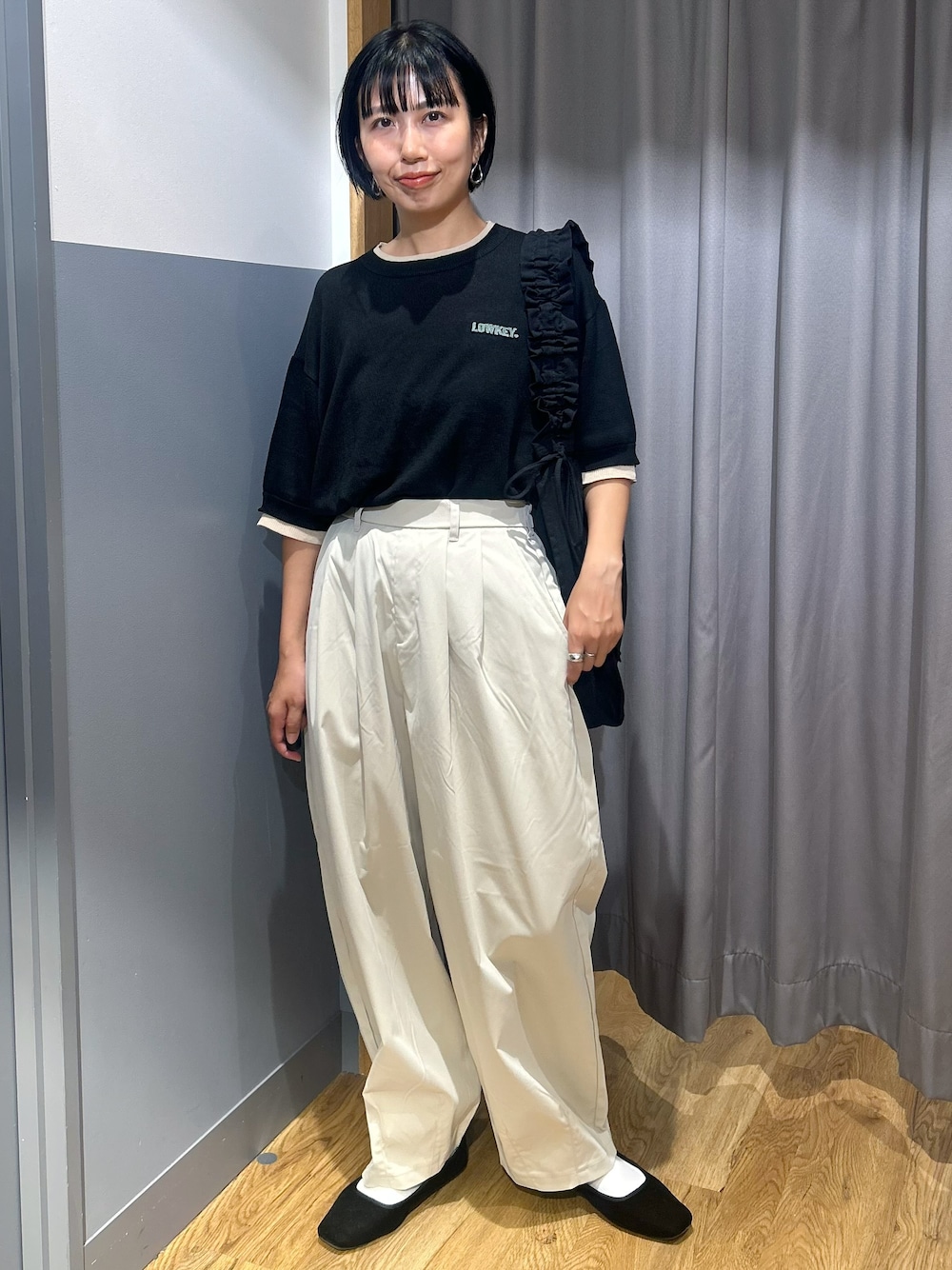 ブラック系のニット/セーター、グレー系のその他パンツ、ブラック系のトートバッグを着用したレディースの夏コーディネートの2枚目の写真