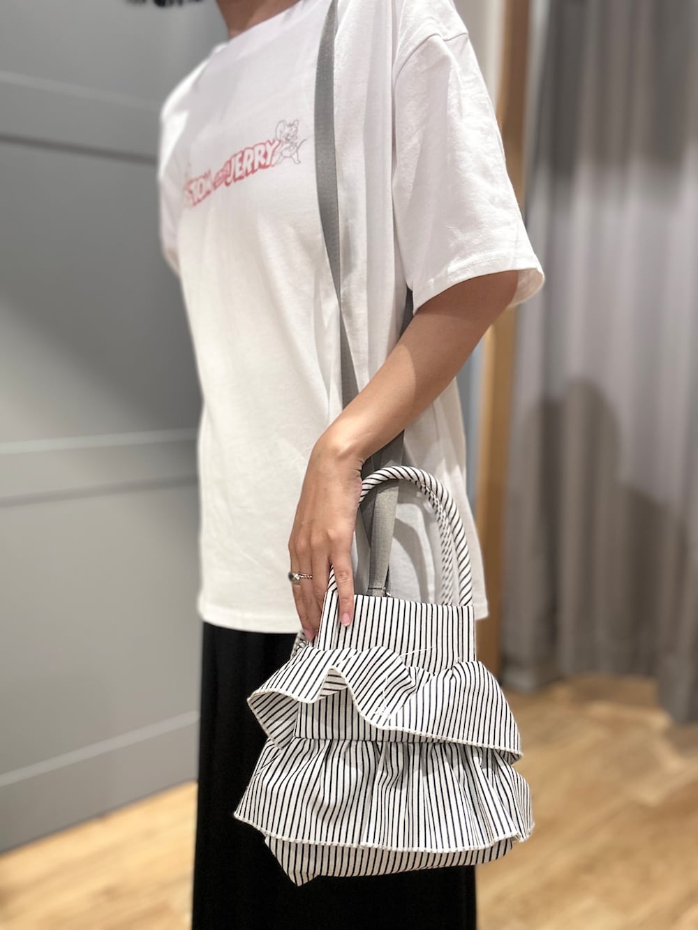 ホワイト系のTシャツ/カットソー、ブラック系のスカート、ホワイト系のショルダーバッグを着用したレディースの夏コーディネートの8枚目の写真
