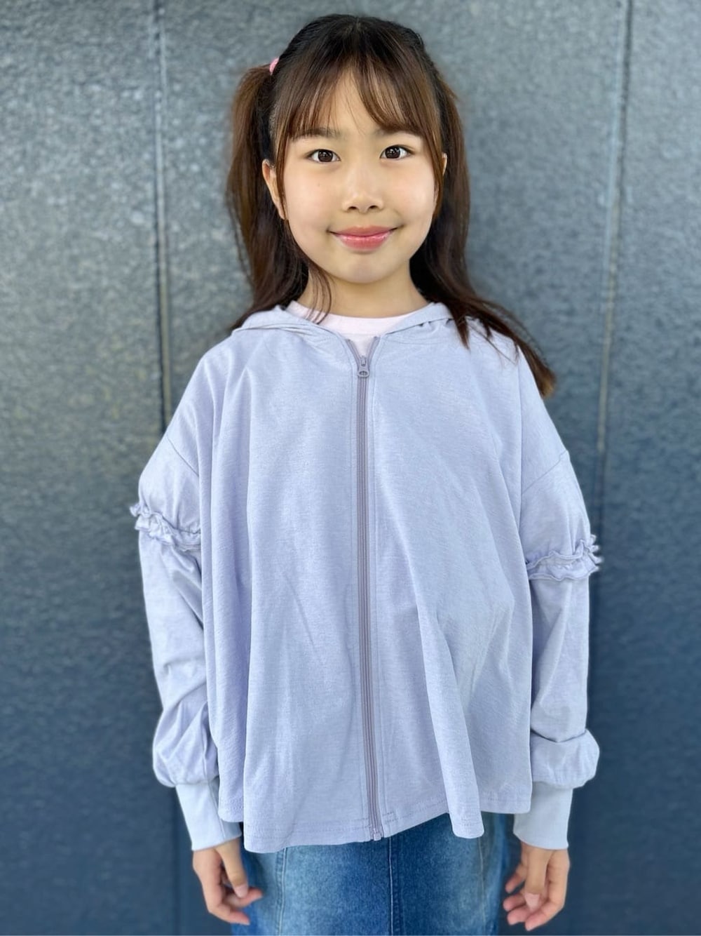 ピンク系のTシャツ/カットソー、ブルー系のデニムスカート、パープル系のパーカーを着用したキッズの春コーディネートの7枚目の写真