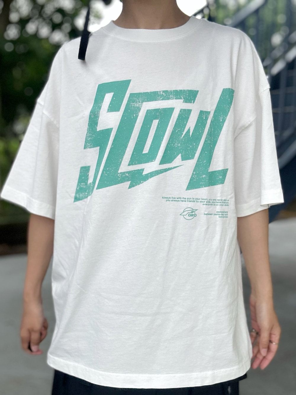 ホワイト系のTシャツ/カットソー、ブラック系のスカート、ブラック系のハットを着用したレディースの春コーディネートの5枚目の写真