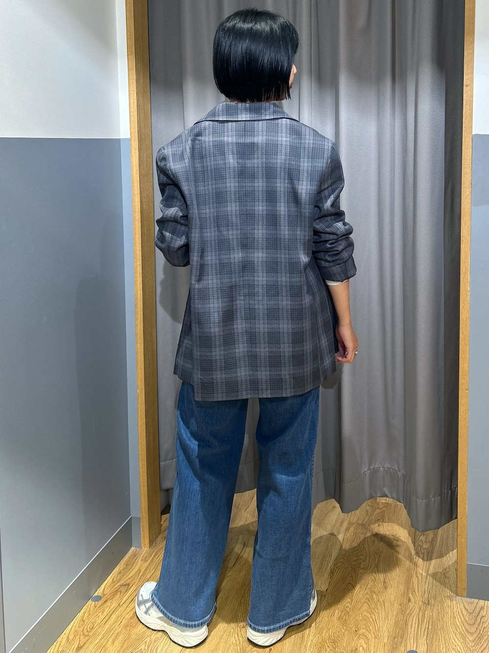 グレー系のテーラードジャケット、グレー系のTシャツ/カットソー、ブルー系のデニムパンツを着用したレディースの秋コーディネートの3枚目の写真