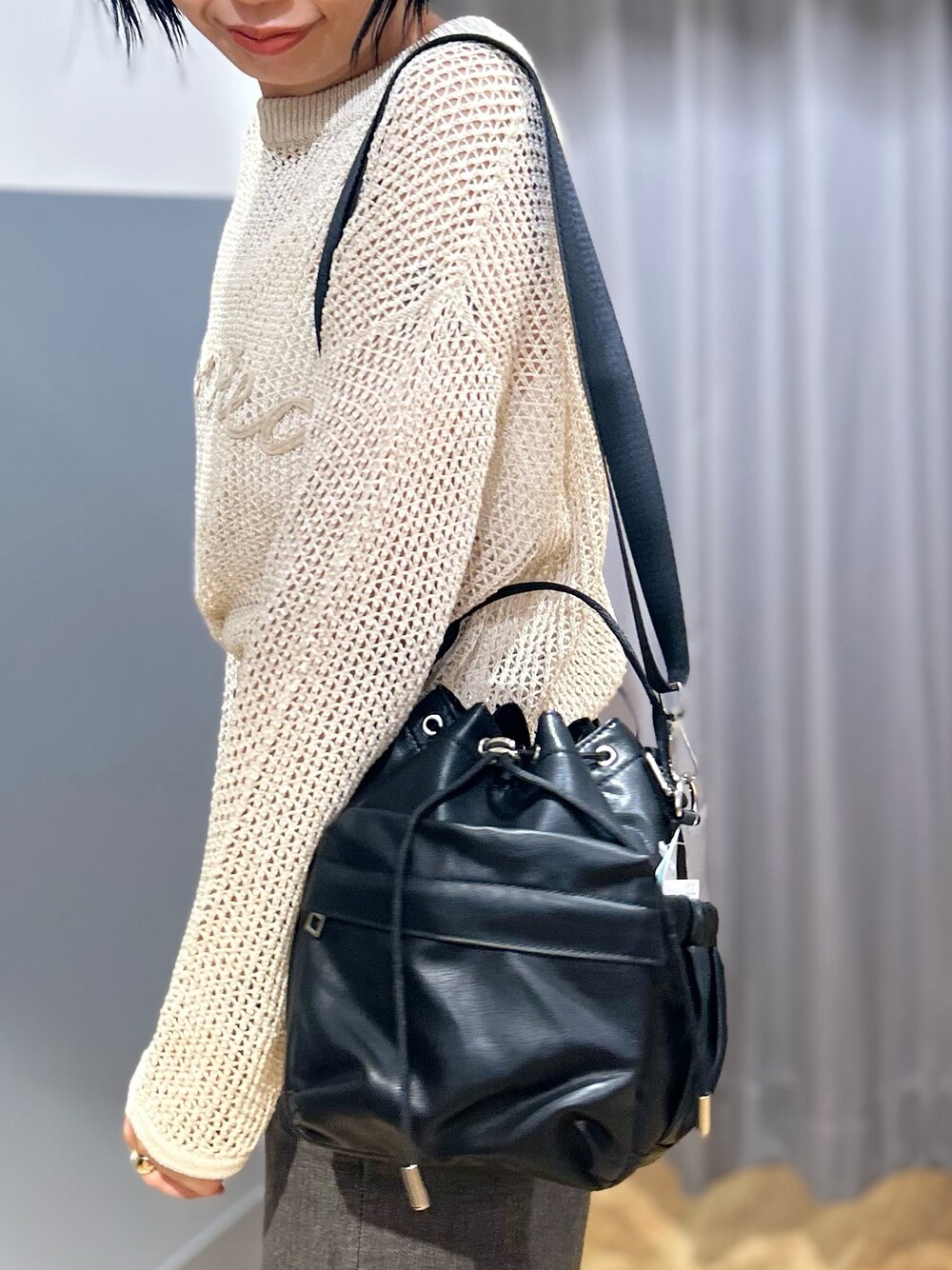 ホワイト系のニット/セーター、ブラウン系のその他パンツ、ブラック系のショルダーバッグを着用したレディースの夏コーディネートの10枚目の写真
