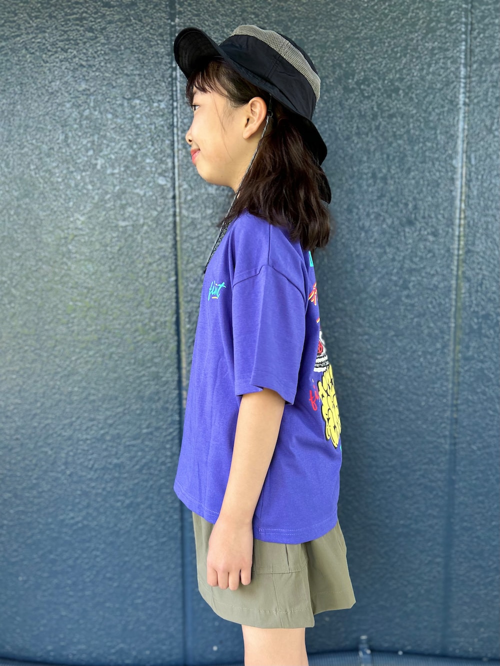 パープル系のTシャツ/カットソー、ブラウン系のスカート、ブラック系のハットを着用したキッズの春コーディネートの6枚目の写真