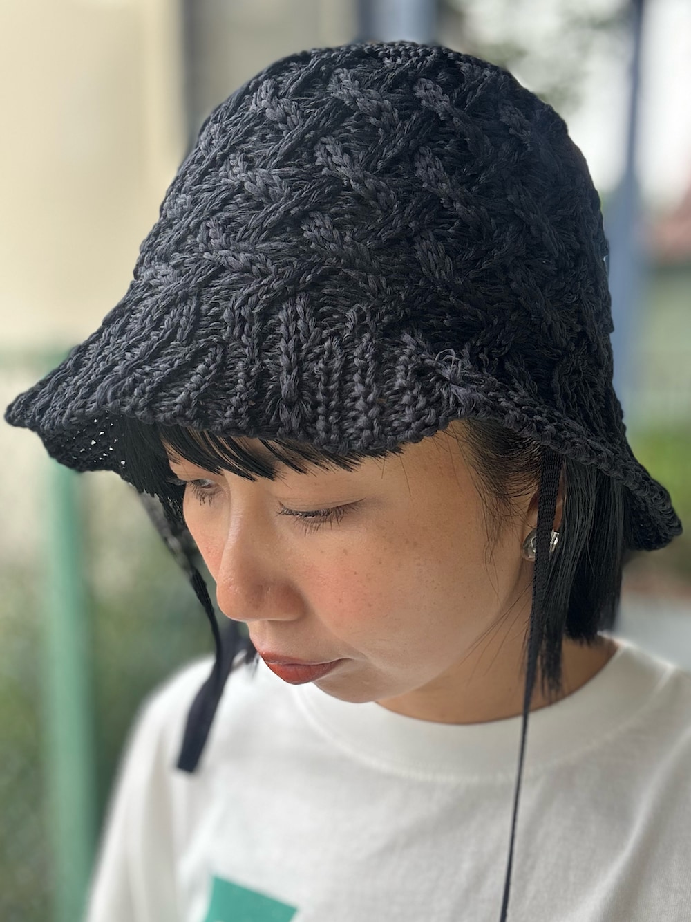 ホワイト系のTシャツ/カットソー、ブラック系のスカート、ブラック系のハットを着用したレディースの春コーディネートの8枚目の写真