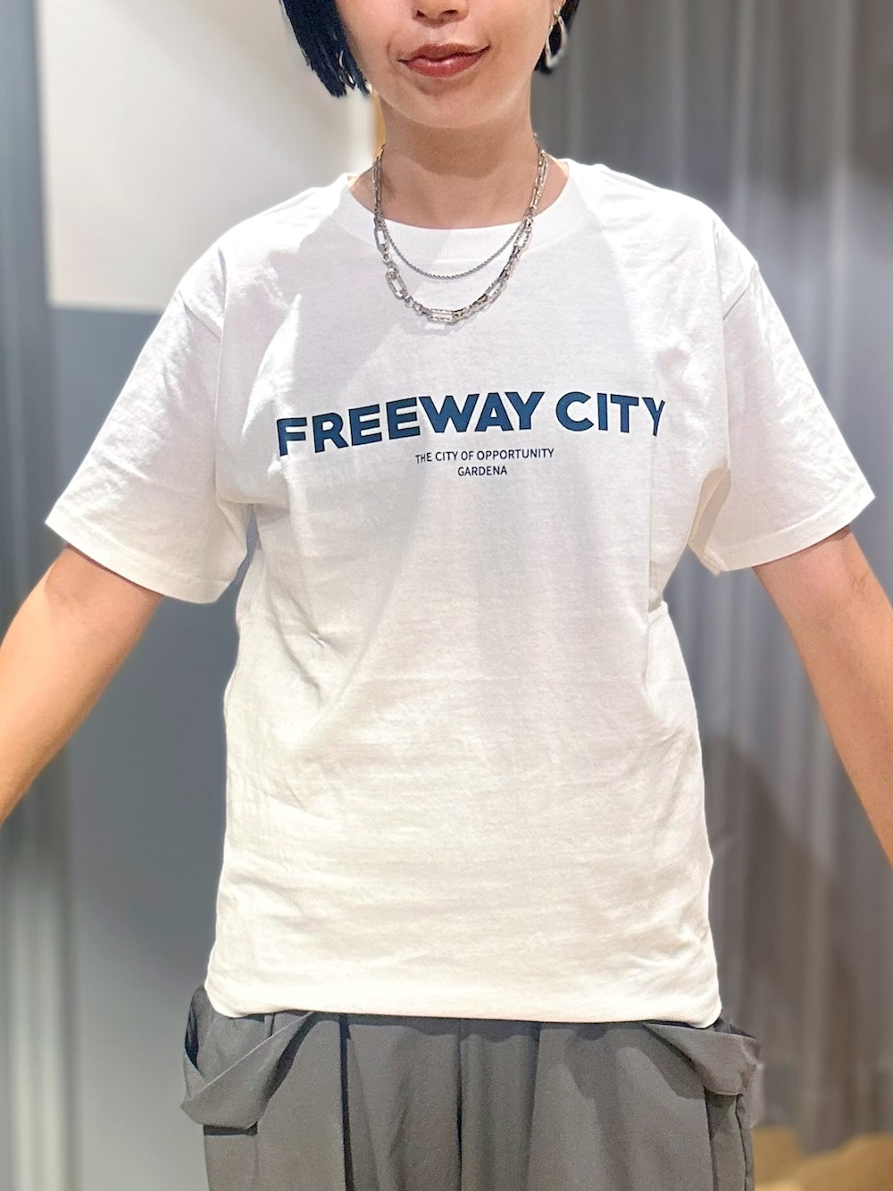 ホワイト系のTシャツ/カットソー、グリーン系のサロペット/オーバーオール、ブラック系のトートバッグを着用したレディースの夏コーディネートの7枚目の写真